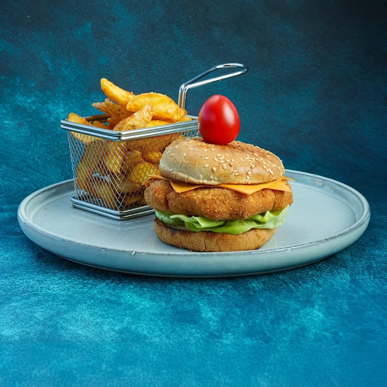 Burger sa pohovanim mesom i wedges krompirom na tanjiru