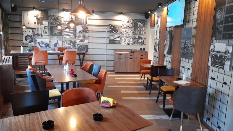 Unutrašnjost restorana PIG BAR sa drvenim stolovima i šarenim stolicama